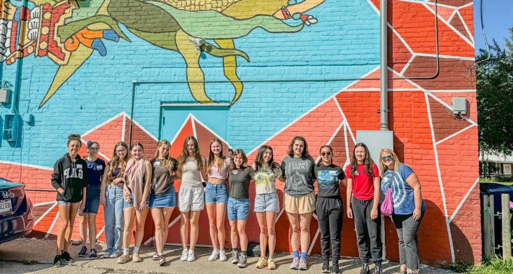 students lined up on colorful wall